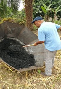 Mr. Ivo Tasong - secretary of FESCAM - recovering the first biochar produced by FESCAM Coop in Cameroon