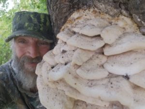 Alan Reed next to large tree mushroom