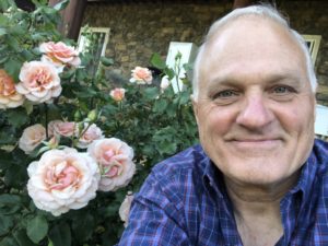 Dennis Amoroso, President of Plant Nutrition Technologies, Inc. posing with his remineralized rose bushes at his California home