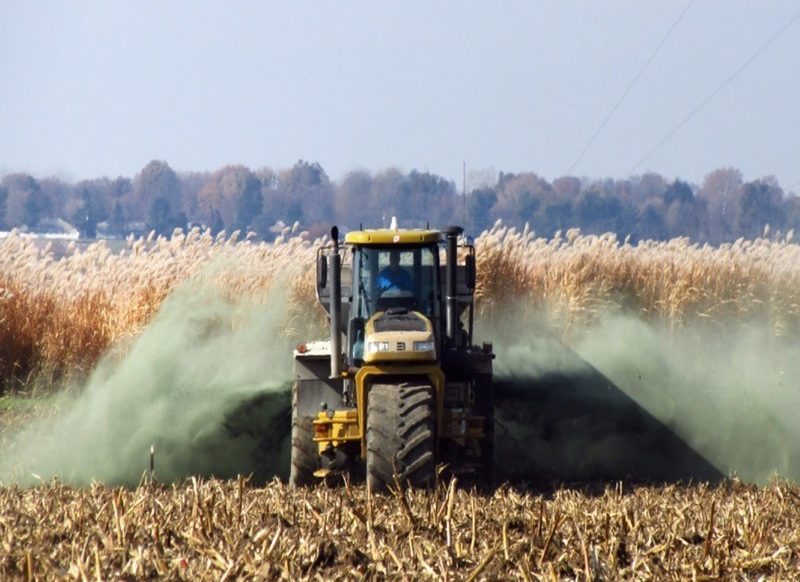 Photo of a tractor spraying rock dust into a field