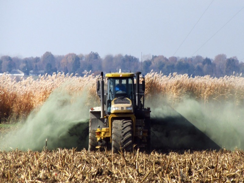 Photo of a tractor spraying rock dust into a field