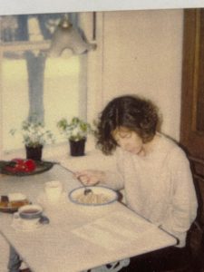 Joanna Campe sitting at the dining room table with the newsletter on the table