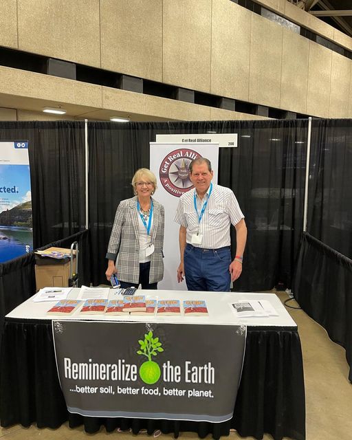 David Munson with other person at a Remineralize the Earth table in a convention center
