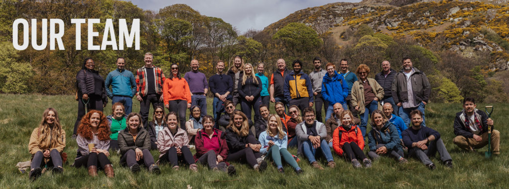 Approximately 40 people posed on a hillside, with the label "Our Team"