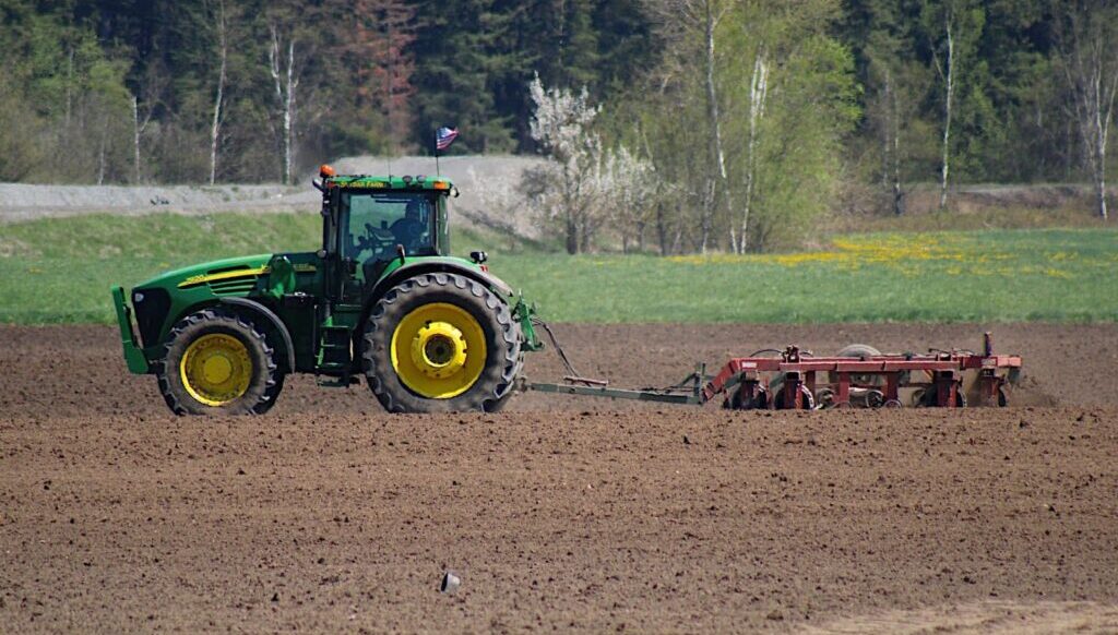Tractor dragging plow in field